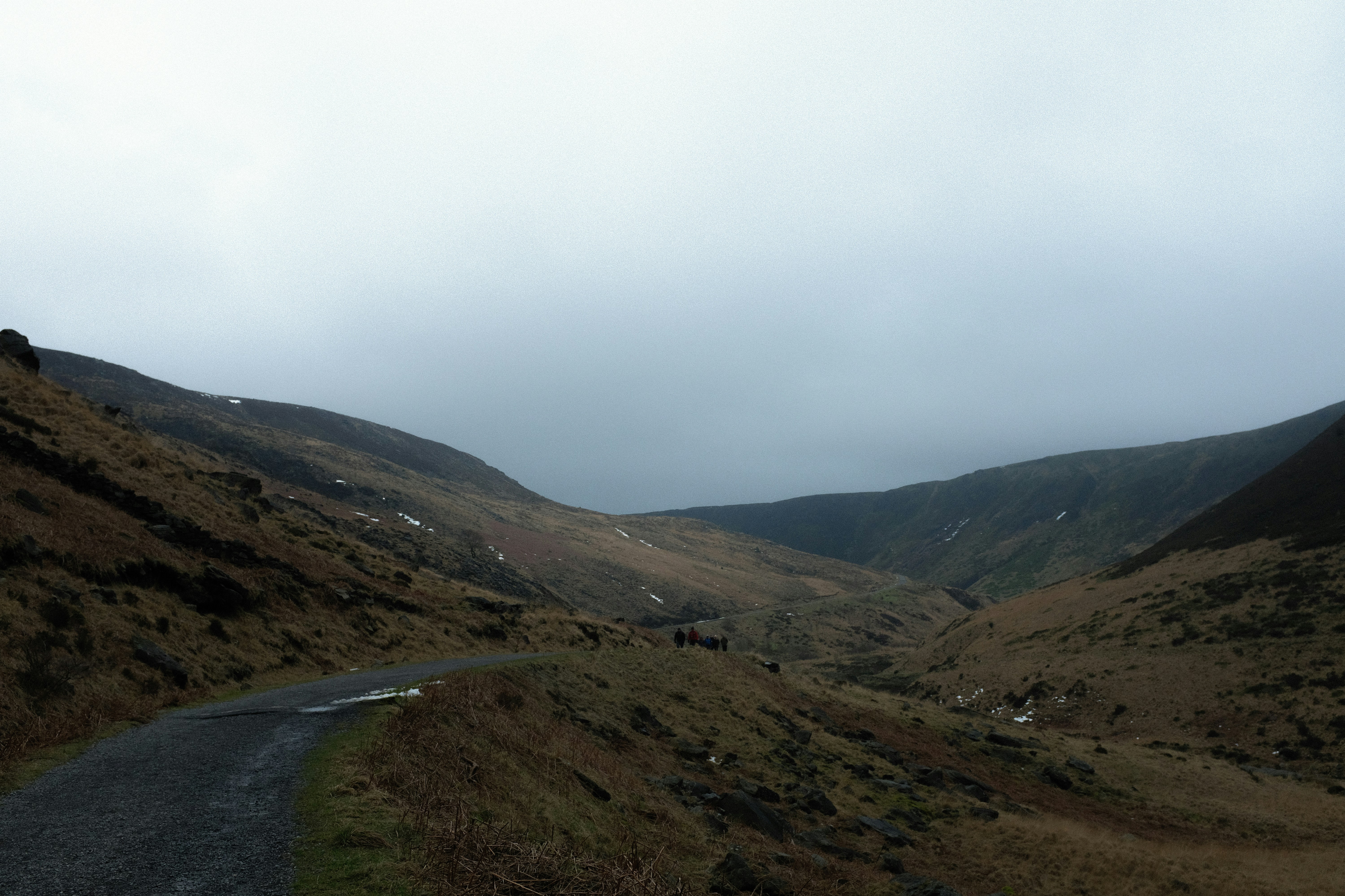 a road going through a valley with mountains in the background, 