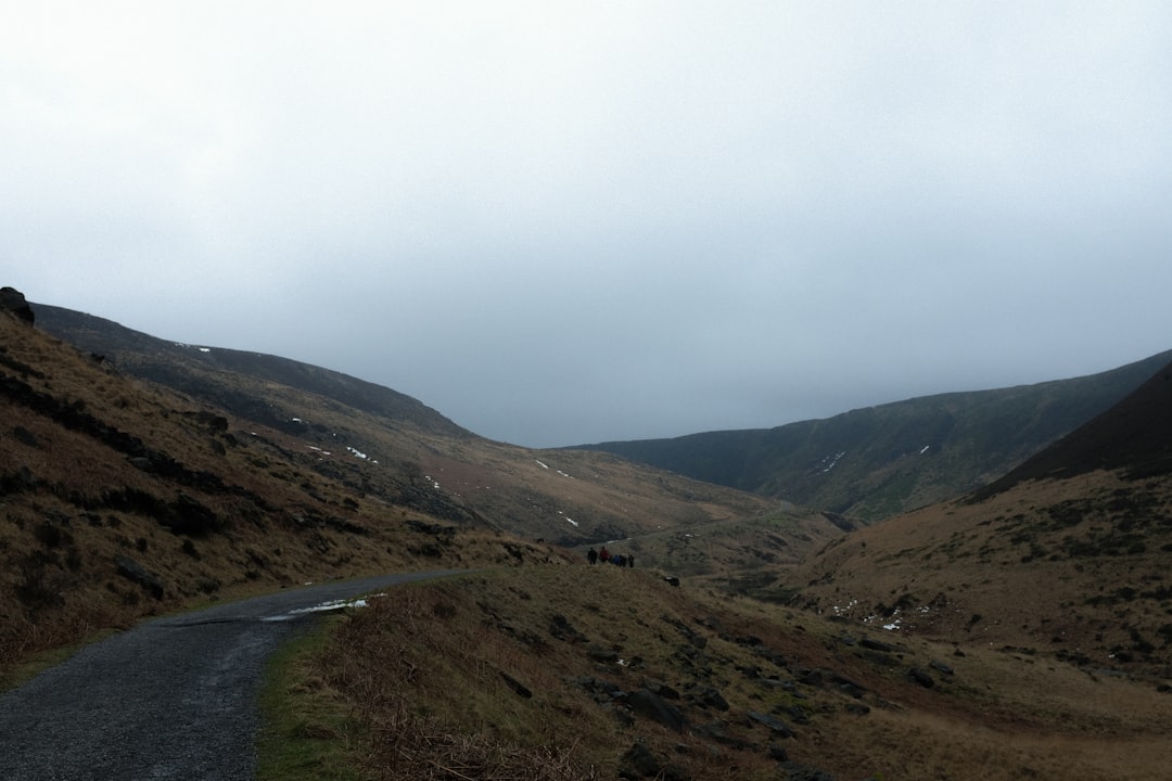 a road going through a valley with mountains in the background,