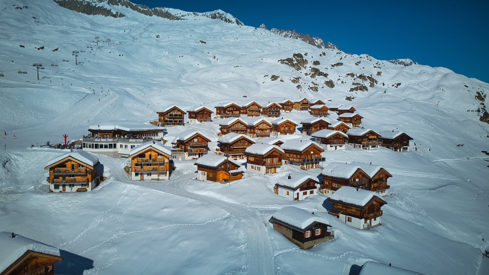 uma montanha coberta de neve com um monte de casas em cima dela