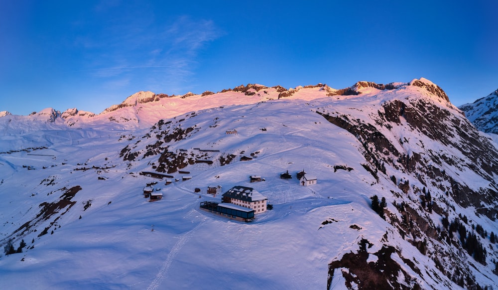 a snowy mountain with a house on top of it