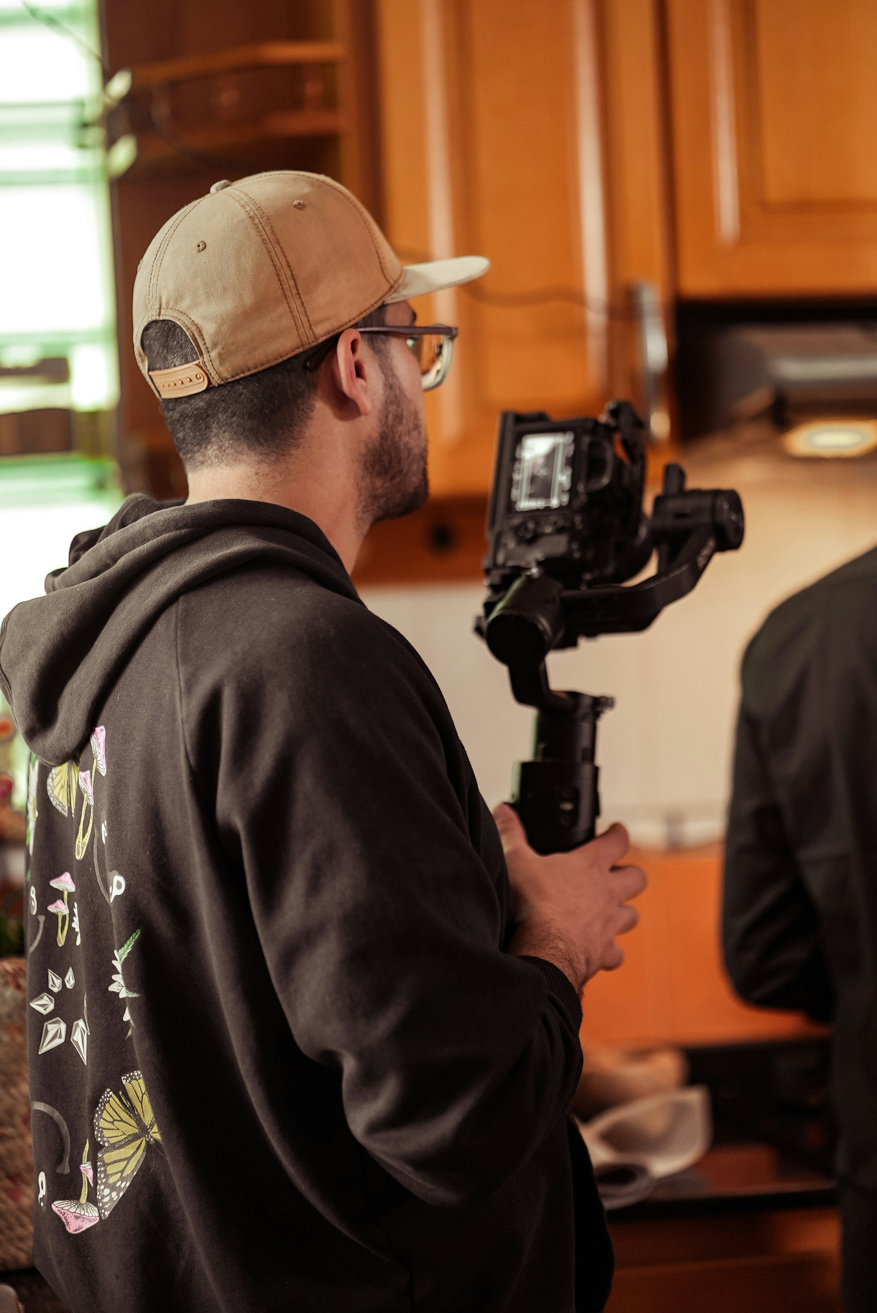 a man holding a camera in a kitchen