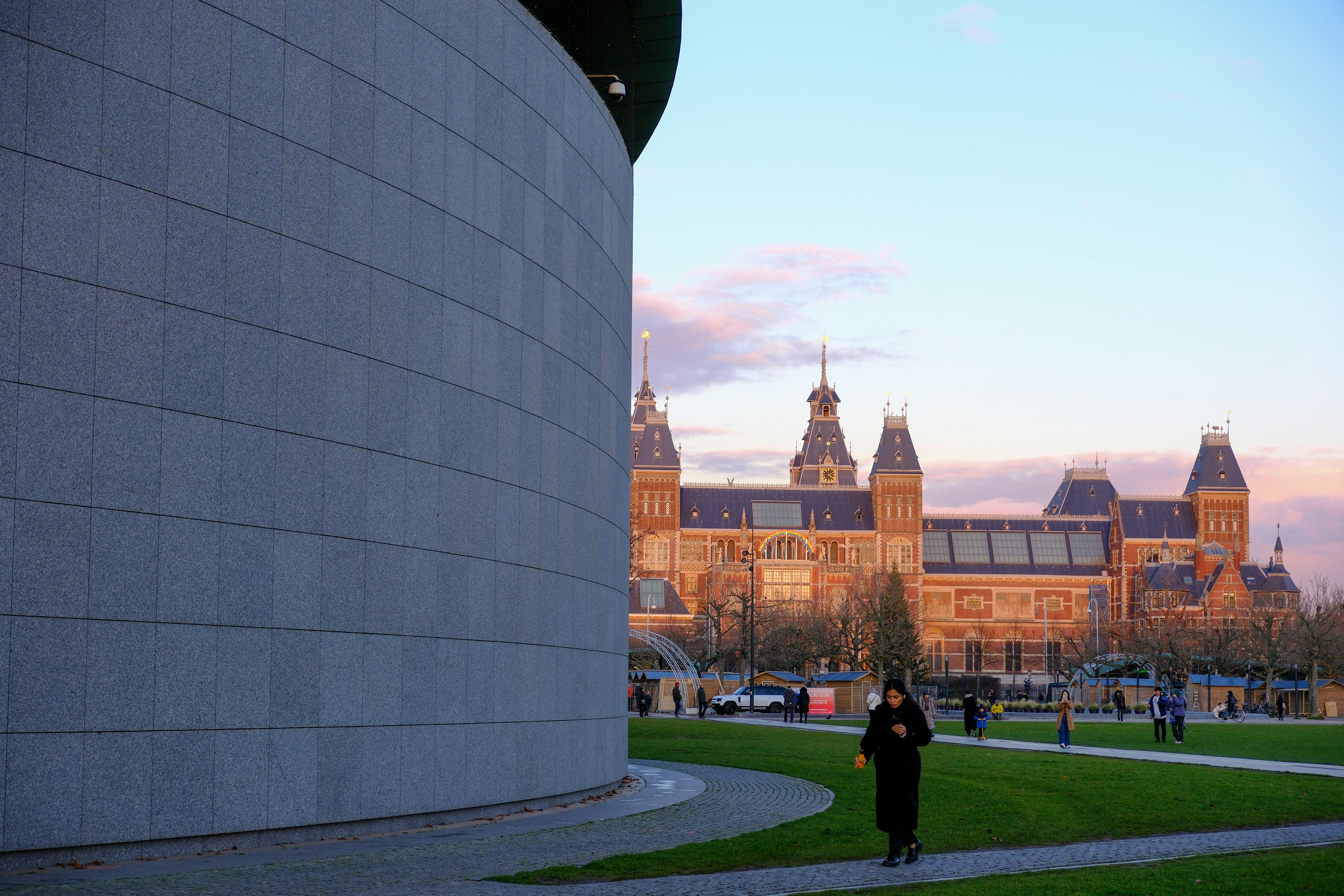 une femme debout devant un grand bâtiment