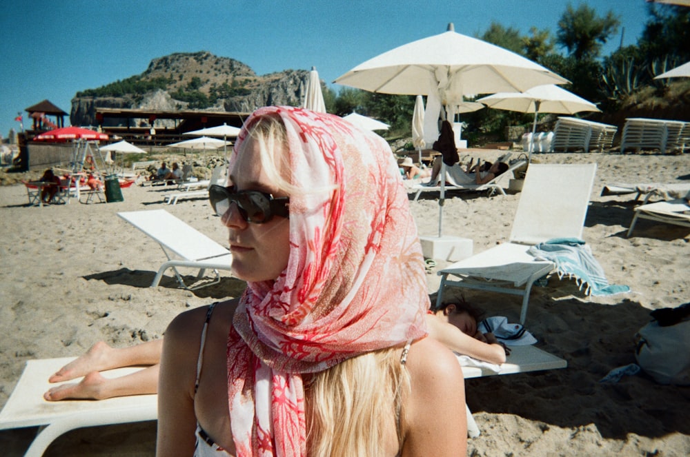 a woman wearing a scarf on a beach