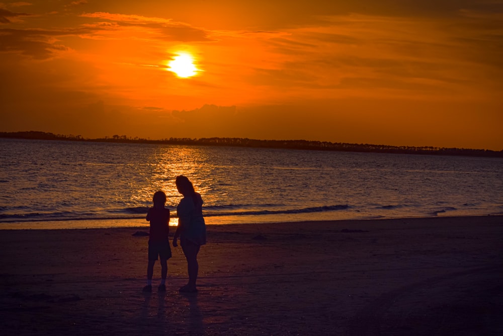 un couple de personnes debout au sommet d’une plage