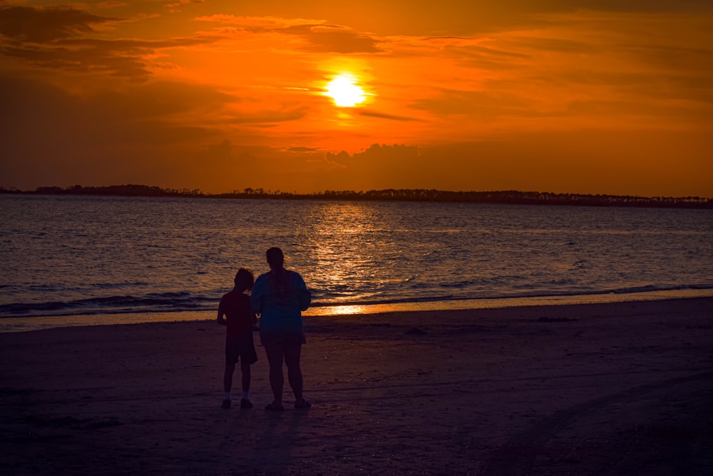 un couple de personnes debout au sommet d’une plage