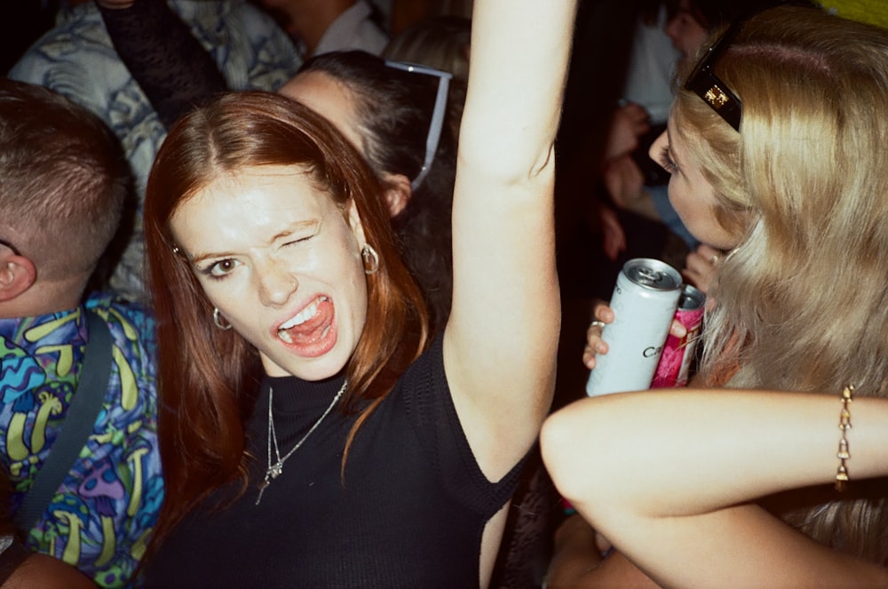 a group of people at a party with a woman holding a can