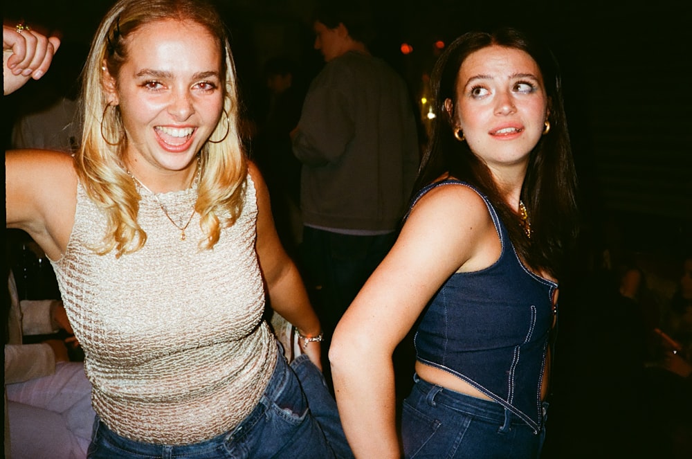 two women standing next to each other at a party