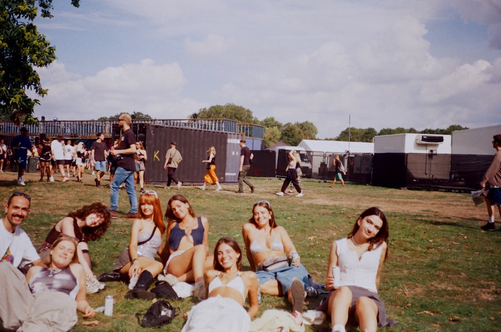 um grupo de pessoas sentadas em cima de um campo verde exuberante