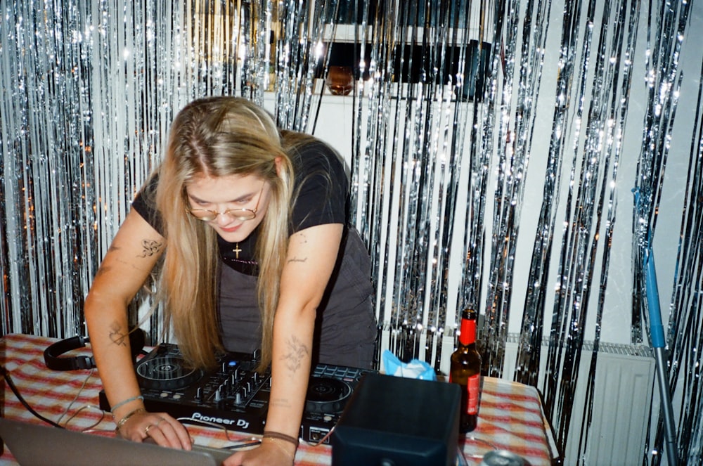 Uma mulher com cabelos compridos está DJing em uma mesa
