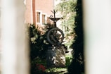 a clock on top of a stone pillar in front of a building