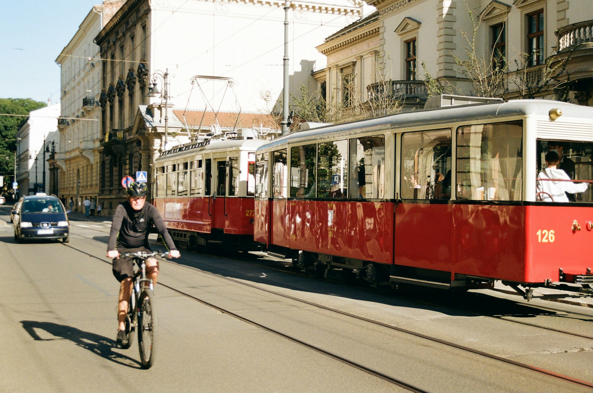 a person riding a bike in front of a trolley car
