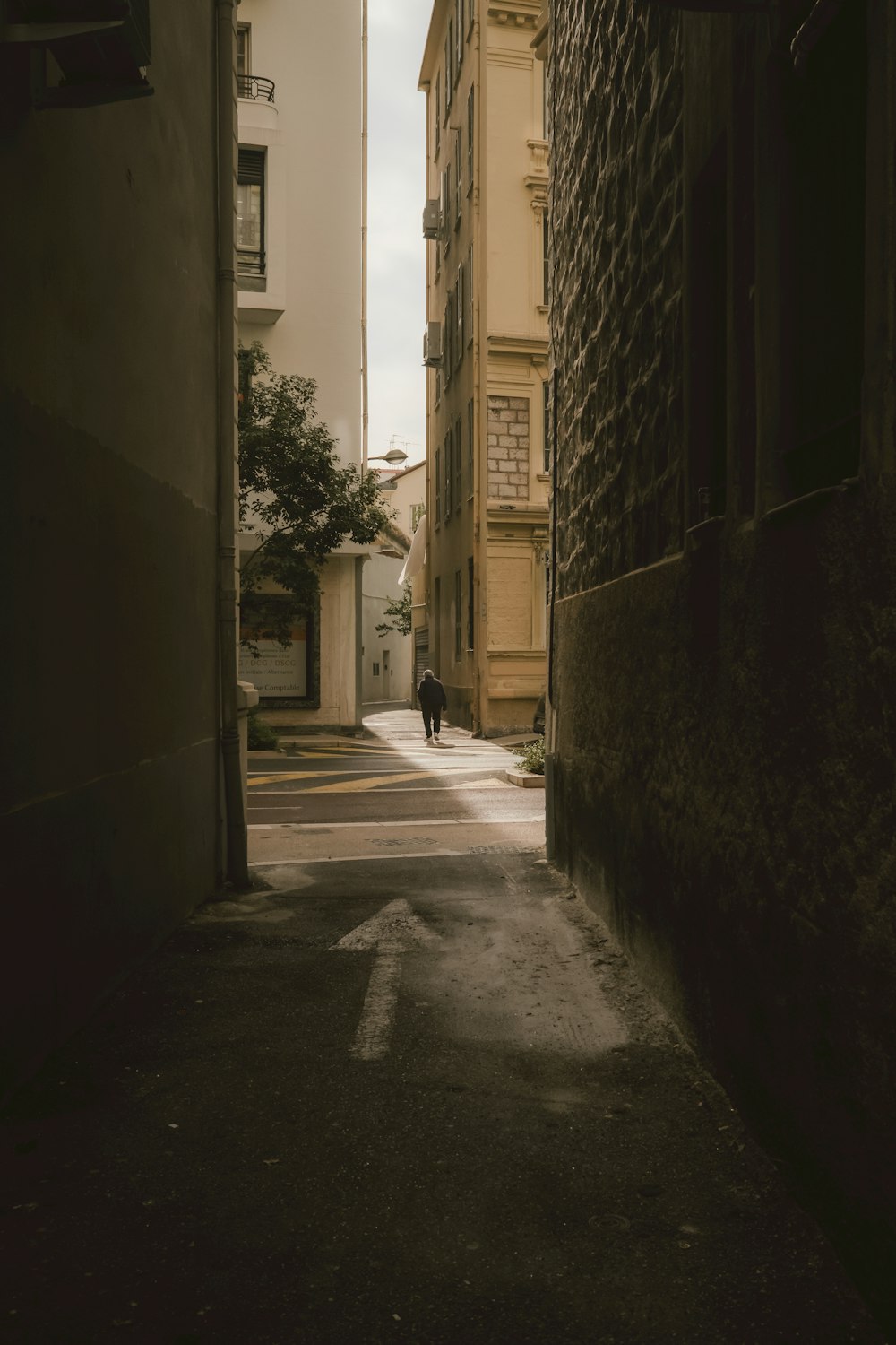 a person walking down a narrow alley way