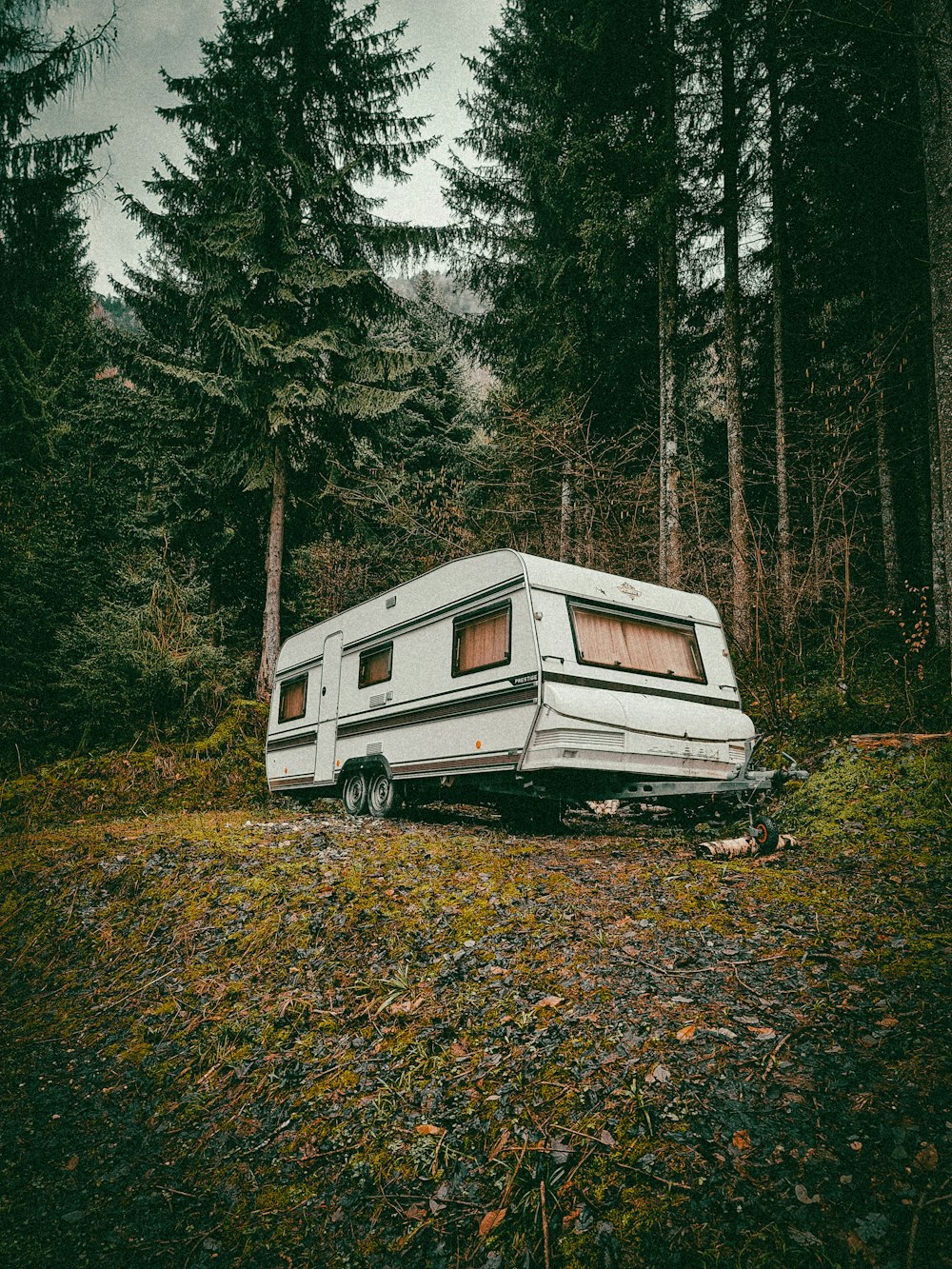 a trailer parked in the middle of a forest