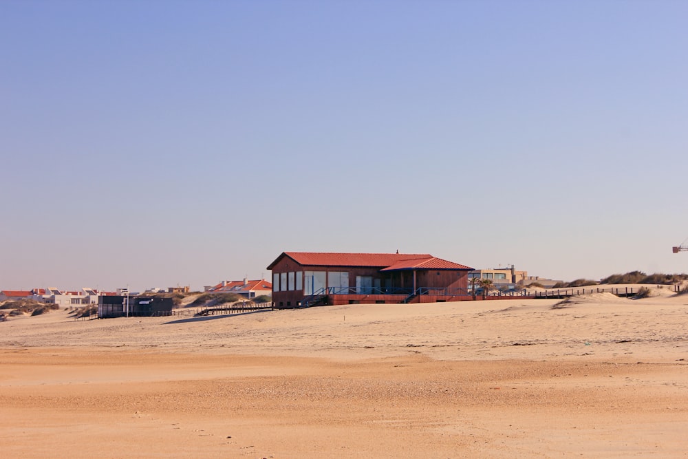 a red building sitting on top of a sandy beach