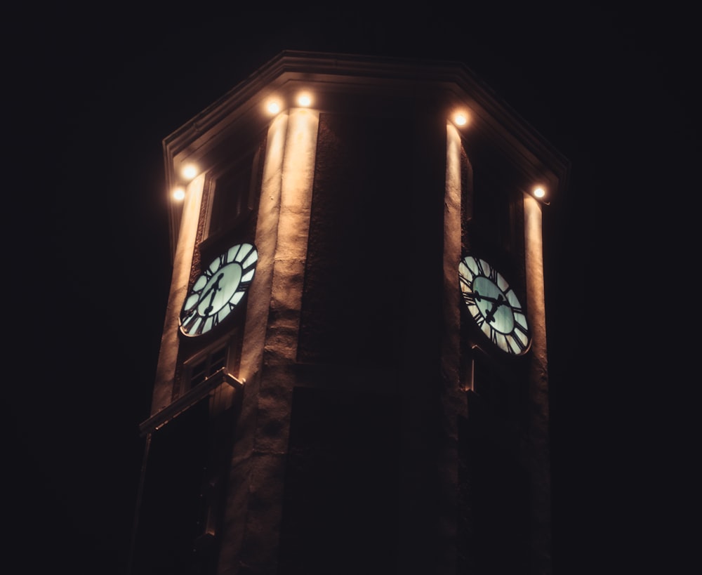 a tall clock tower with two clocks on each of it's sides