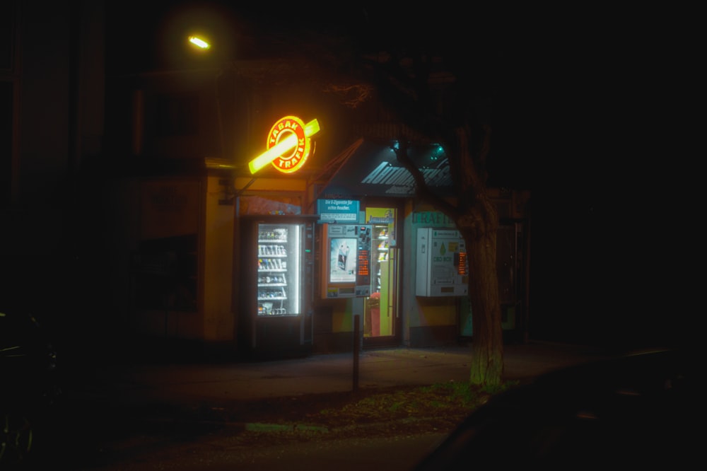 a dark street at night with a neon sign