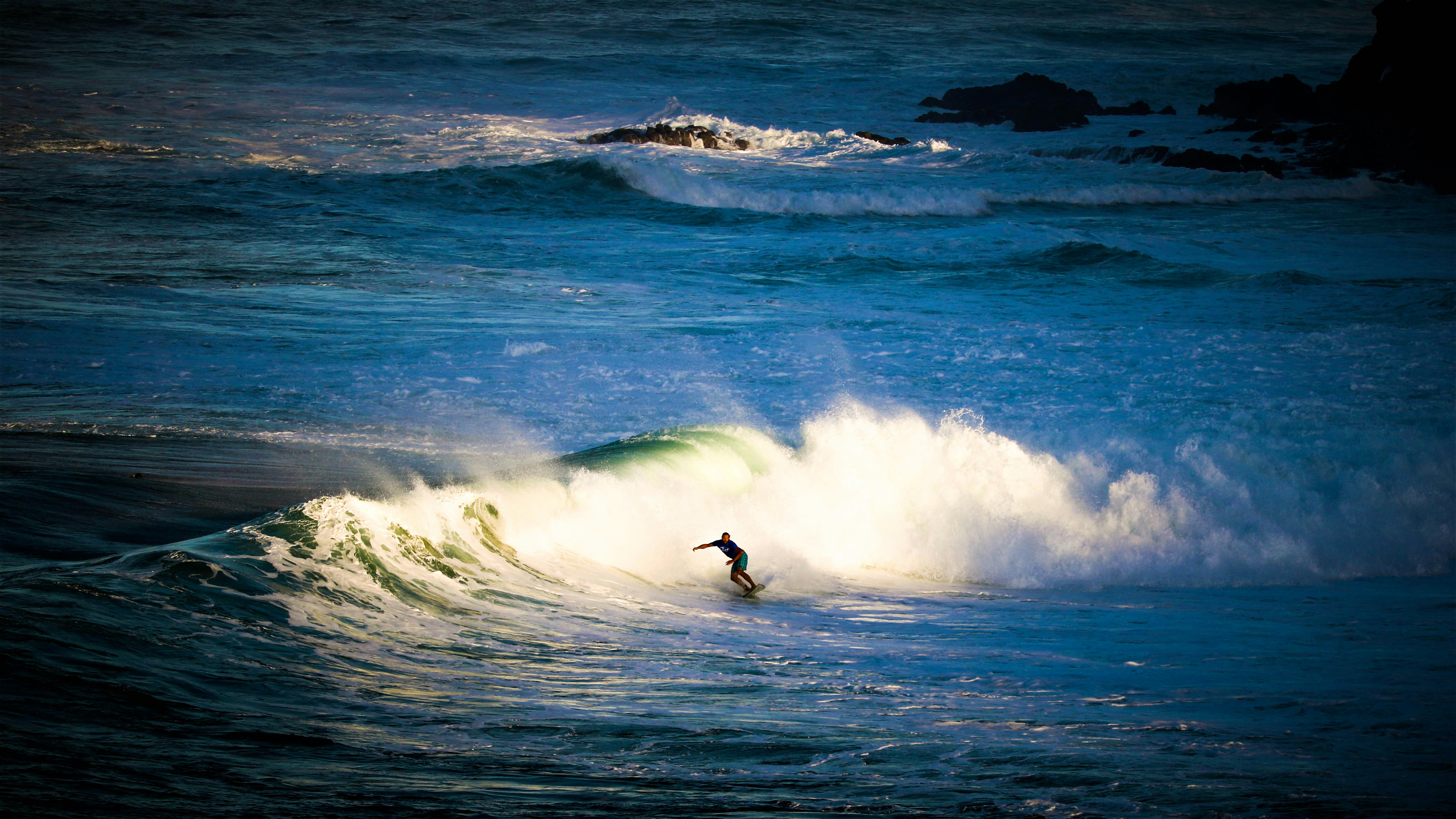 a man riding a wave on top of a surfboard
