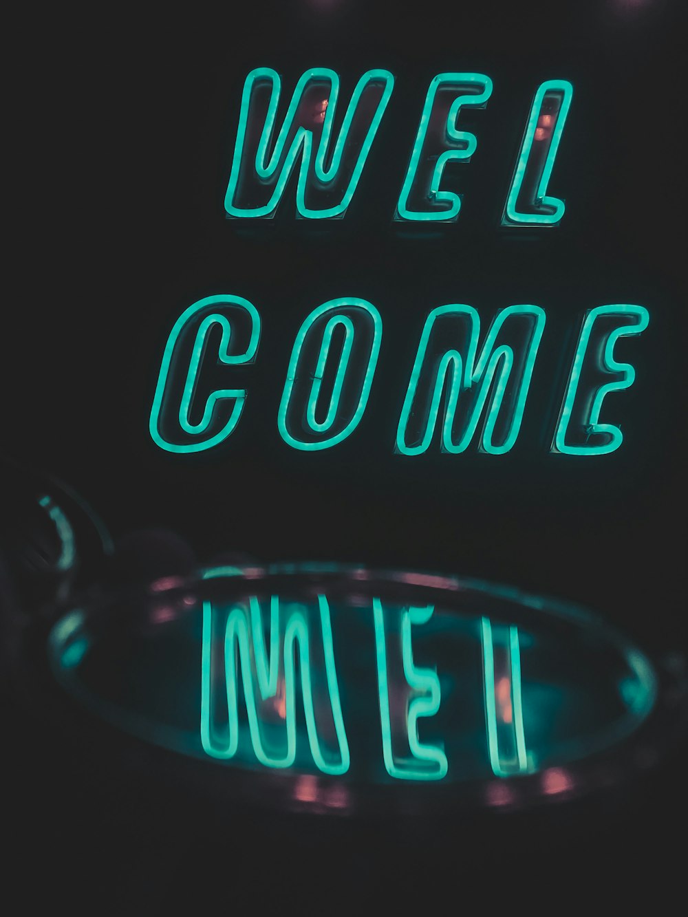 a neon sign that says we'll come under a magnifying glass
