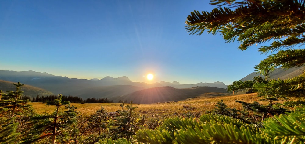 the sun is setting over a mountain range