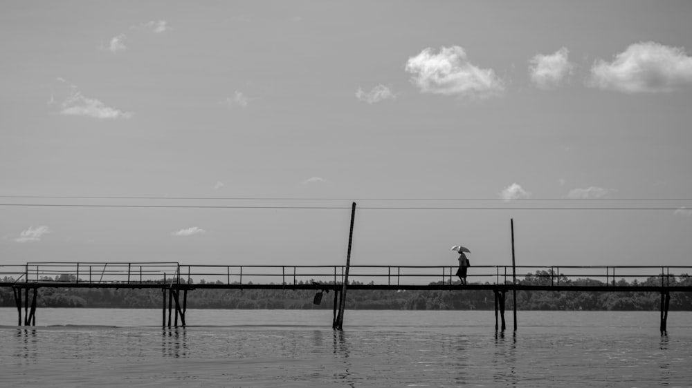 a person walking across a bridge over a body of water