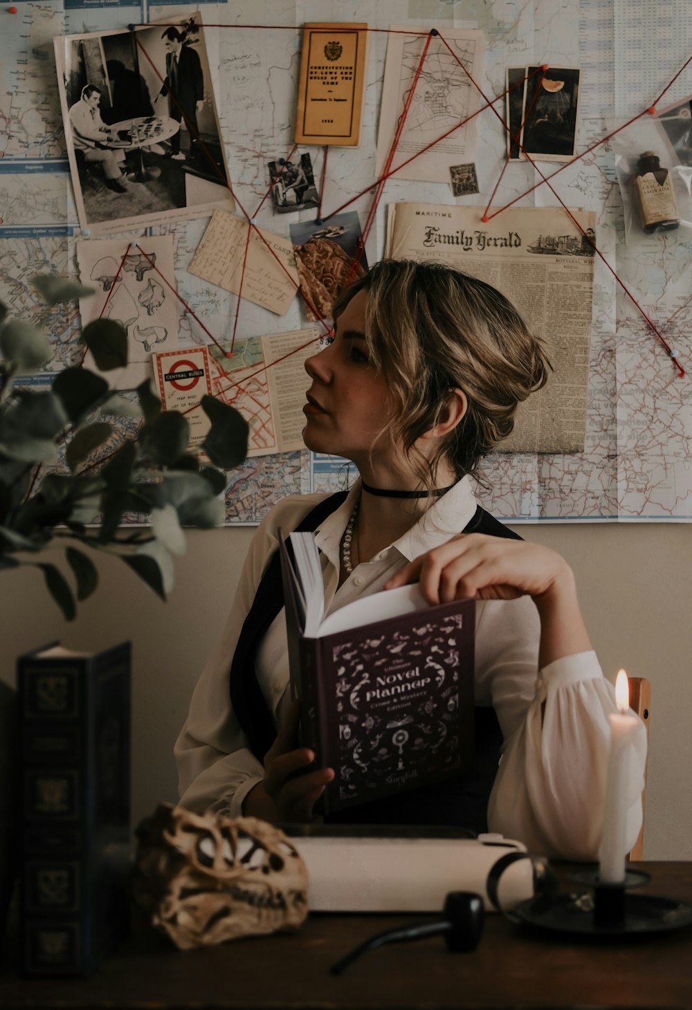 a woman sitting at a desk holding a book