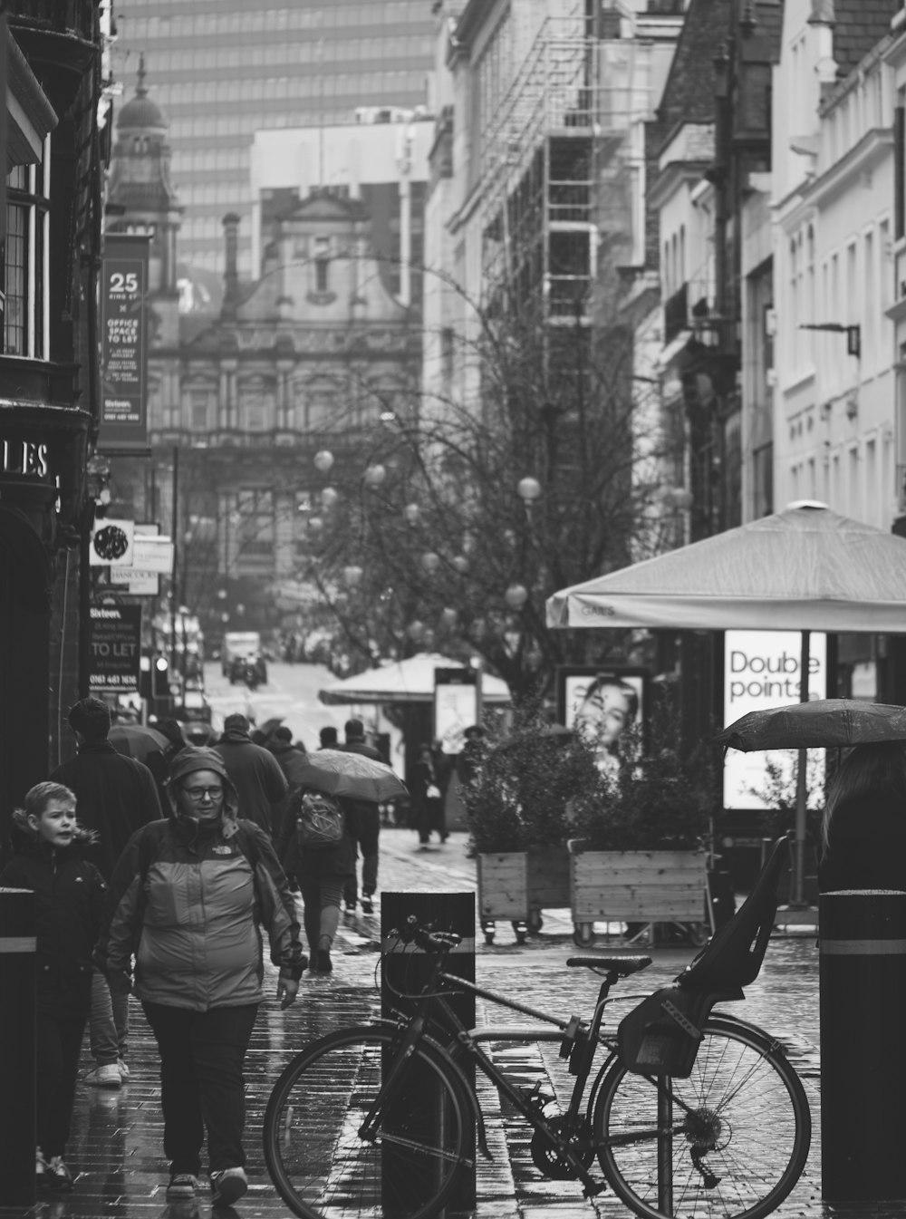 a black and white photo of people walking down a street