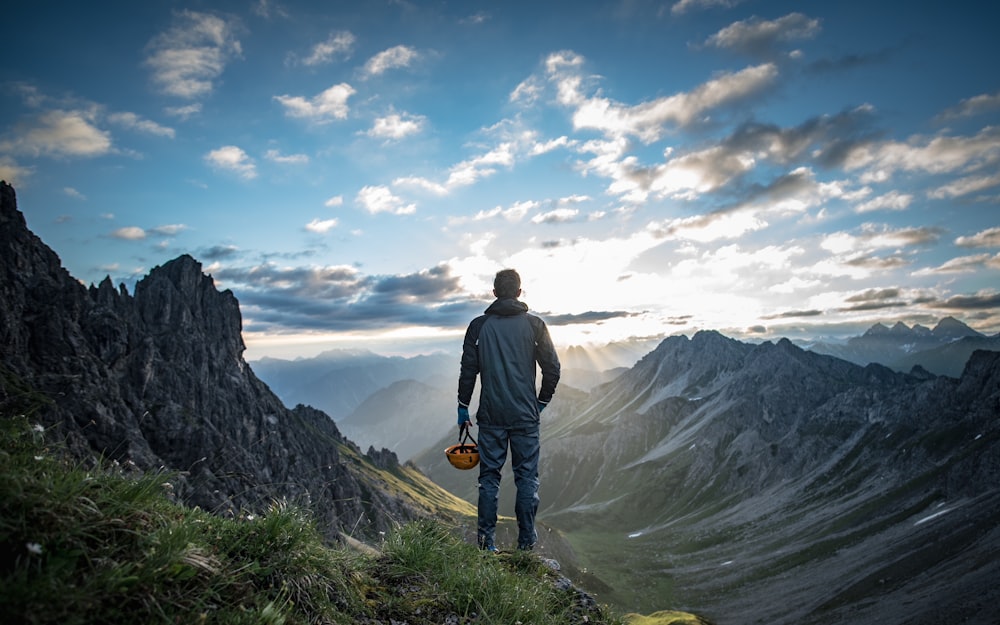 a man standing on top of a lush green hillside