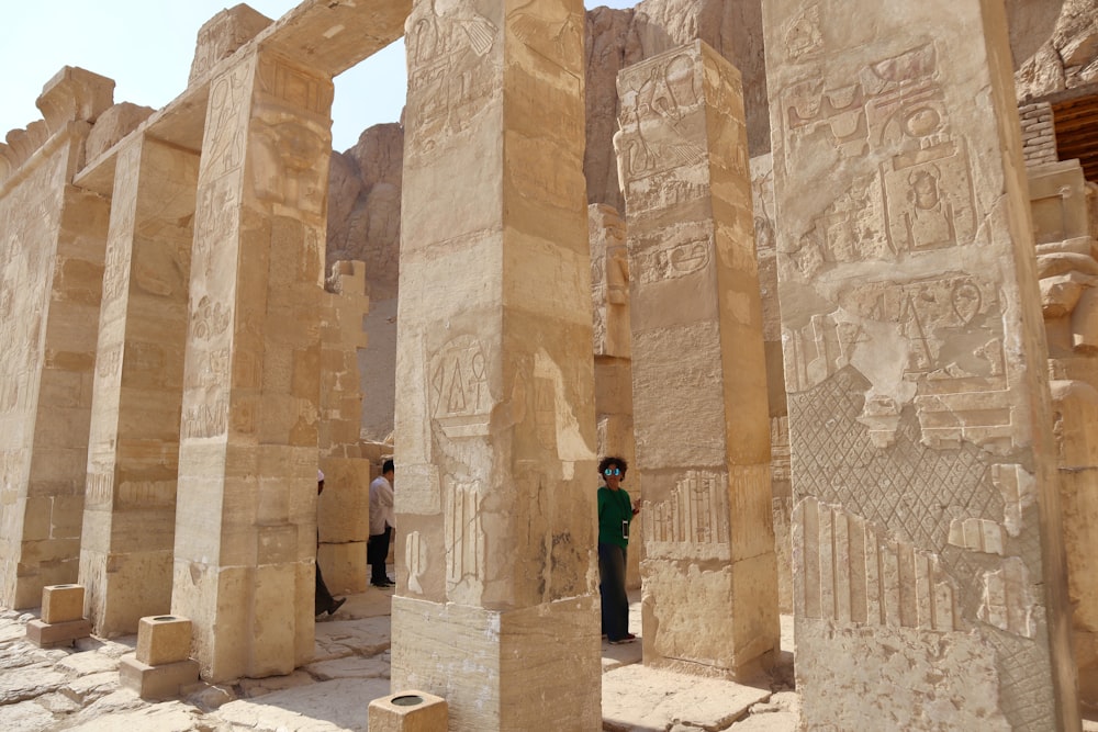 a man standing between two large stone pillars
