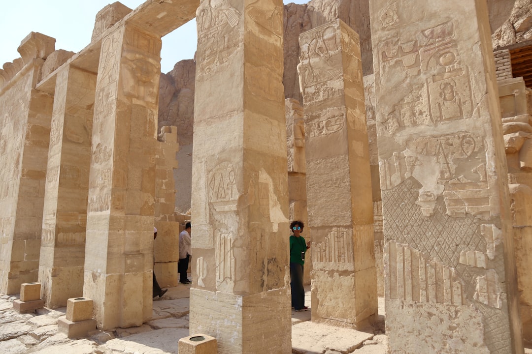 a man standing between two large stone pillars, Mortuary temple of Hatshepsut