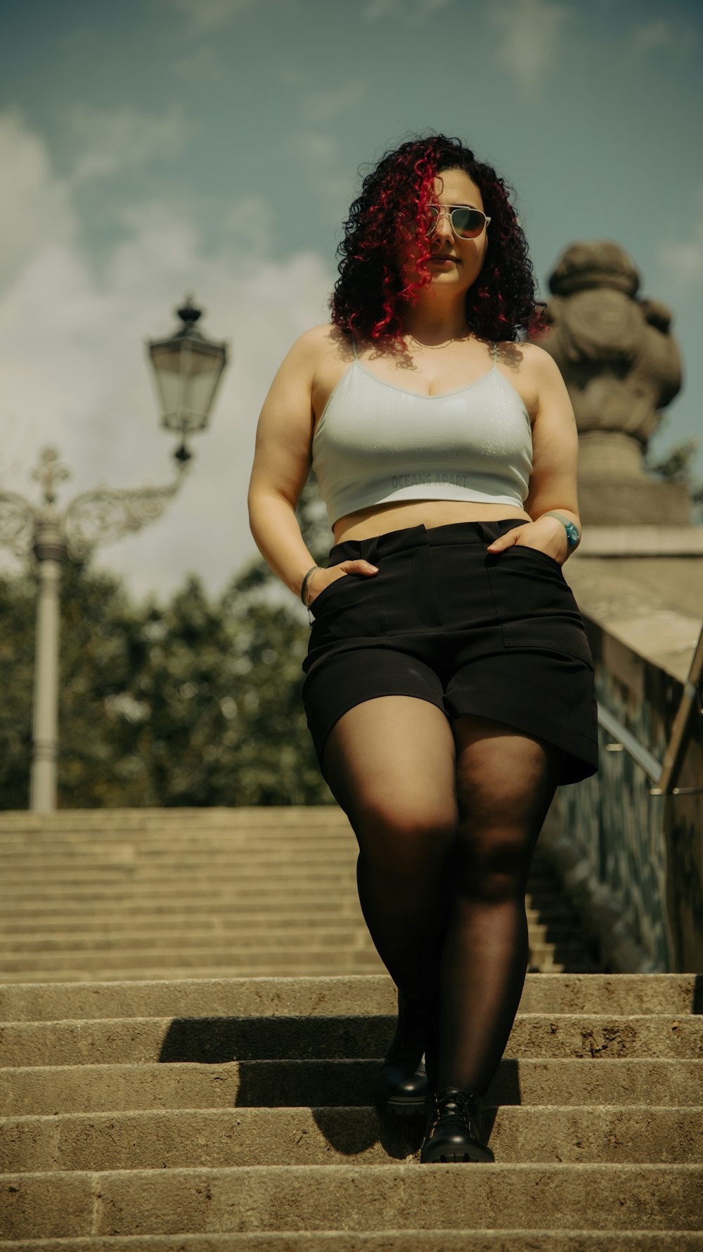 a woman with red hair sitting on a set of stairs
