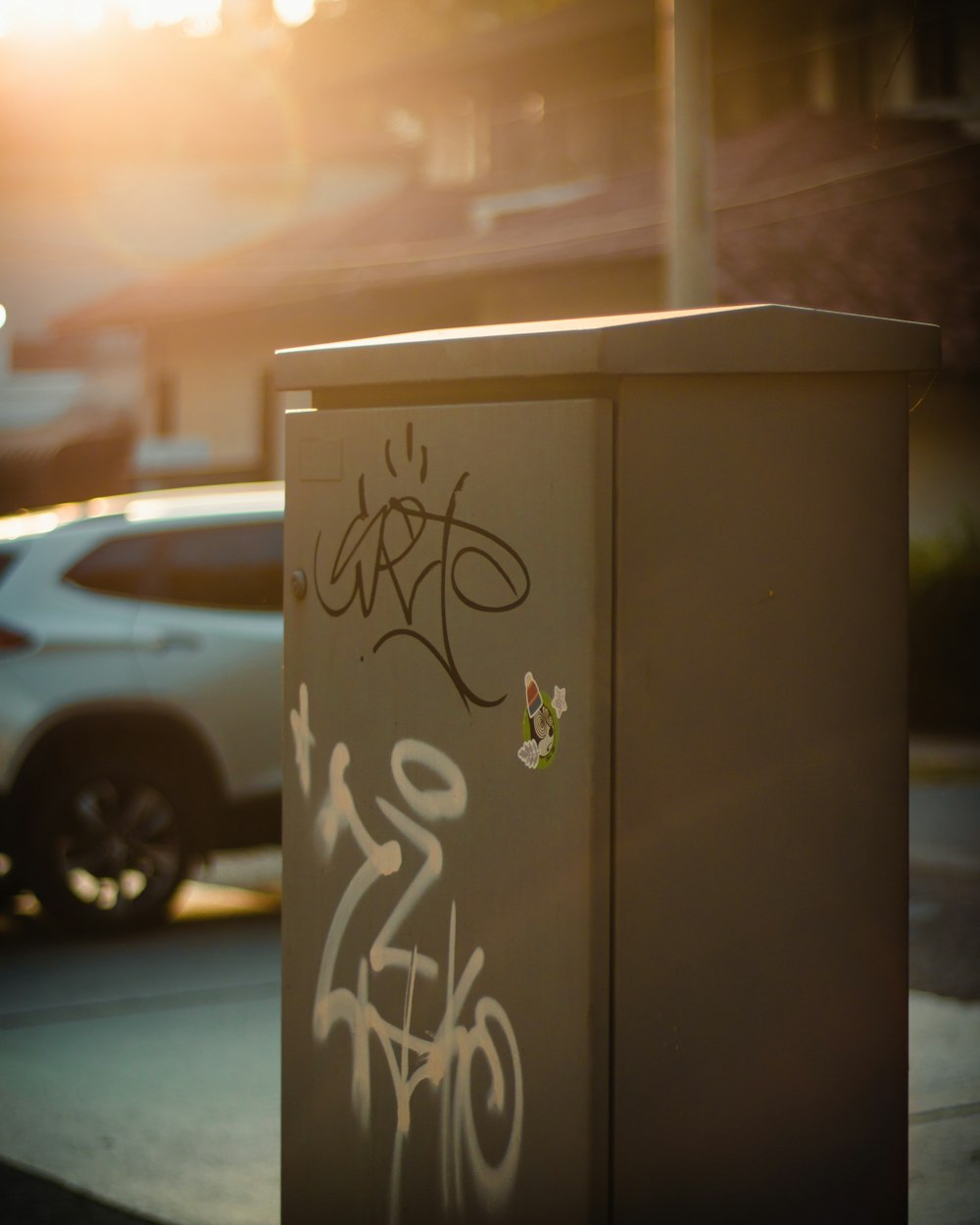a box with graffiti on it sitting on the side of a road