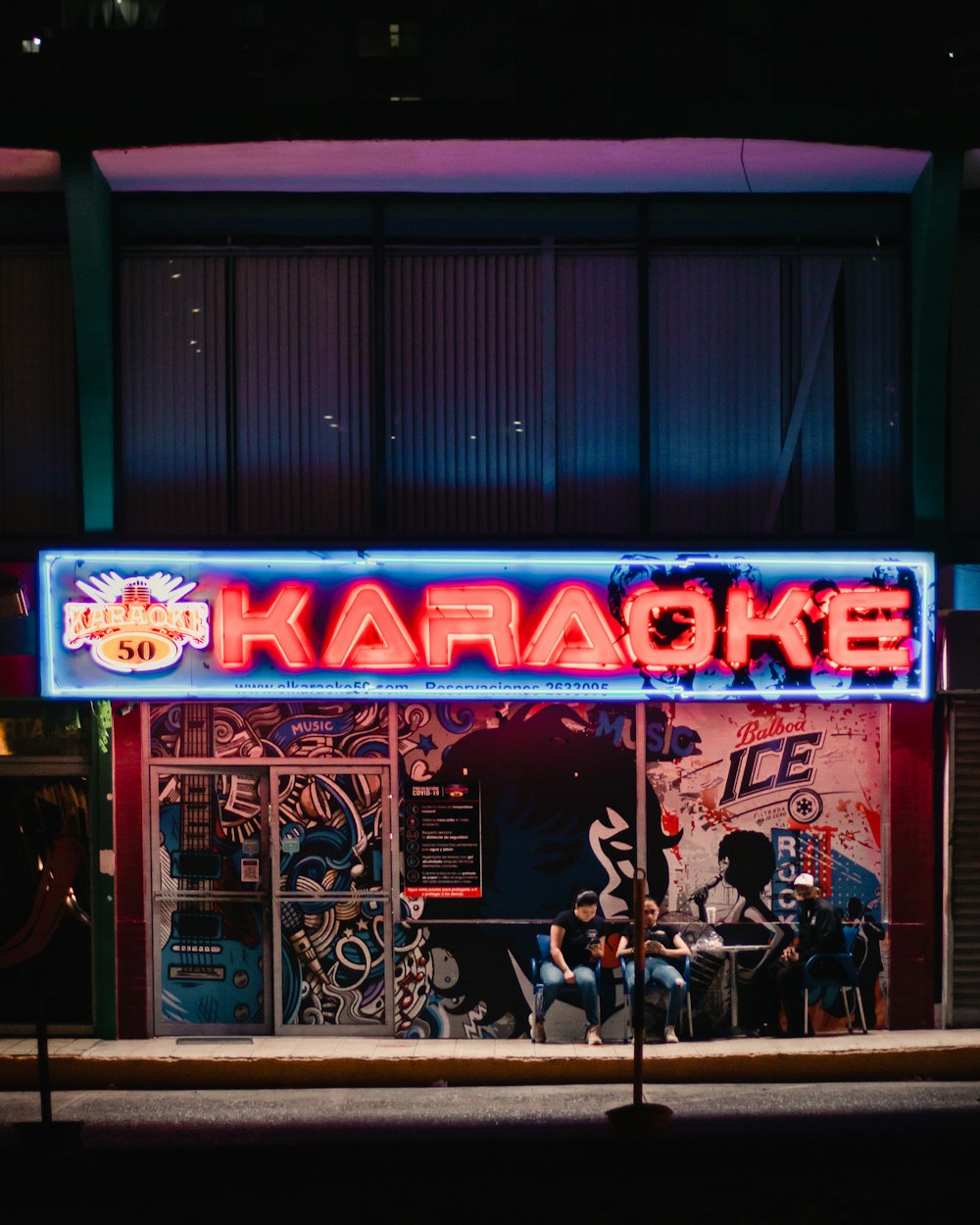a neon sign that reads karaoke on the side of a building