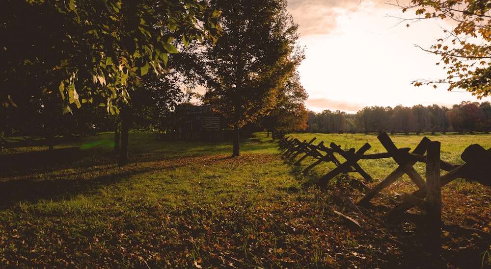 a row of wooden fences sitting in the middle of a field