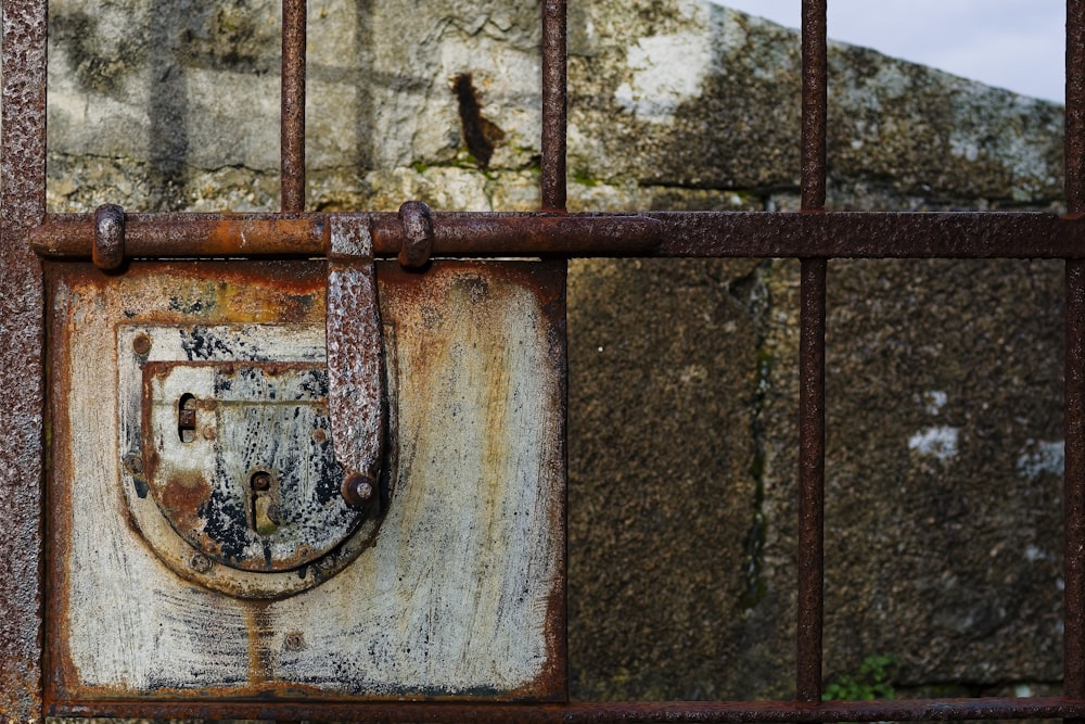 a rusted iron gate with a padlock on it