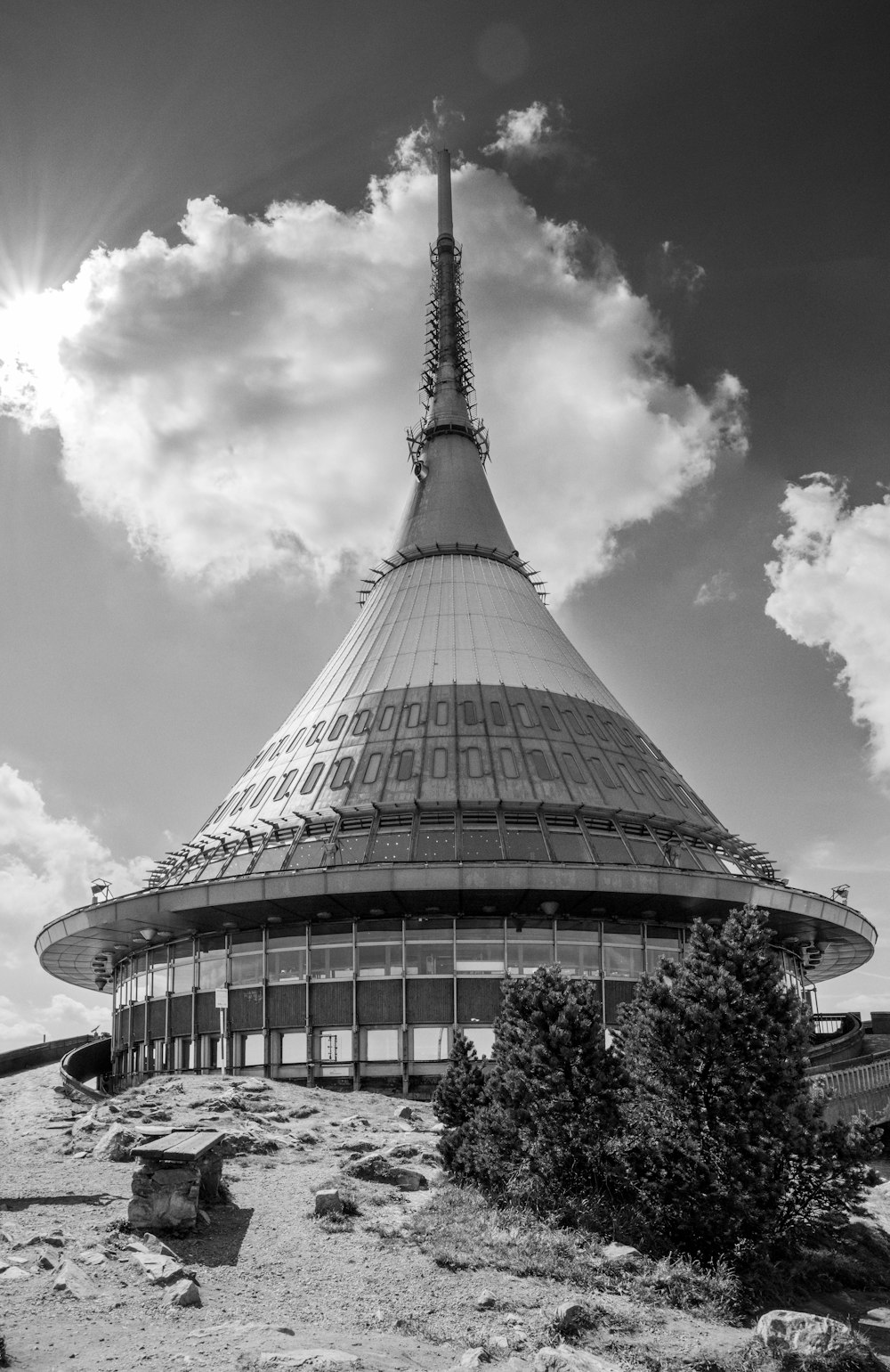 uma foto em preto e branco de um edifício em uma colina