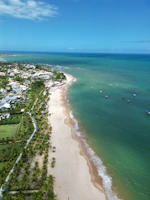 an aerial view of a beach with boats in the water