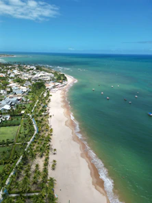 an aerial view of a beach with boats in the water
