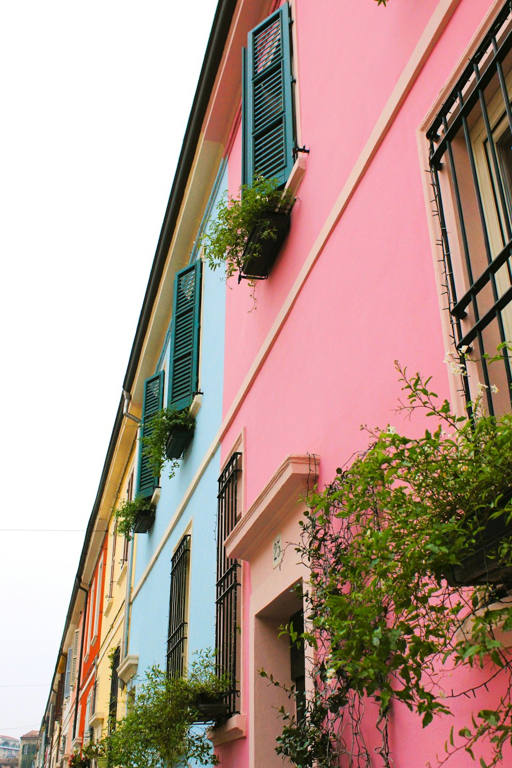 a row of colorful buildings with green shutters