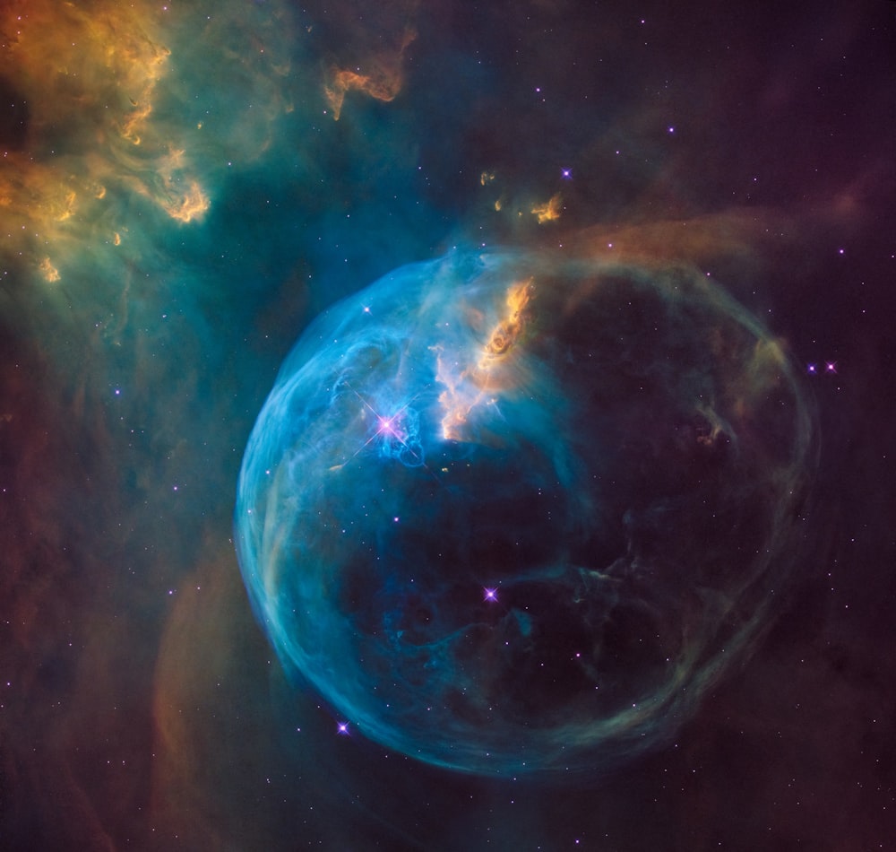 a large blue bubble in the middle of a space filled with stars