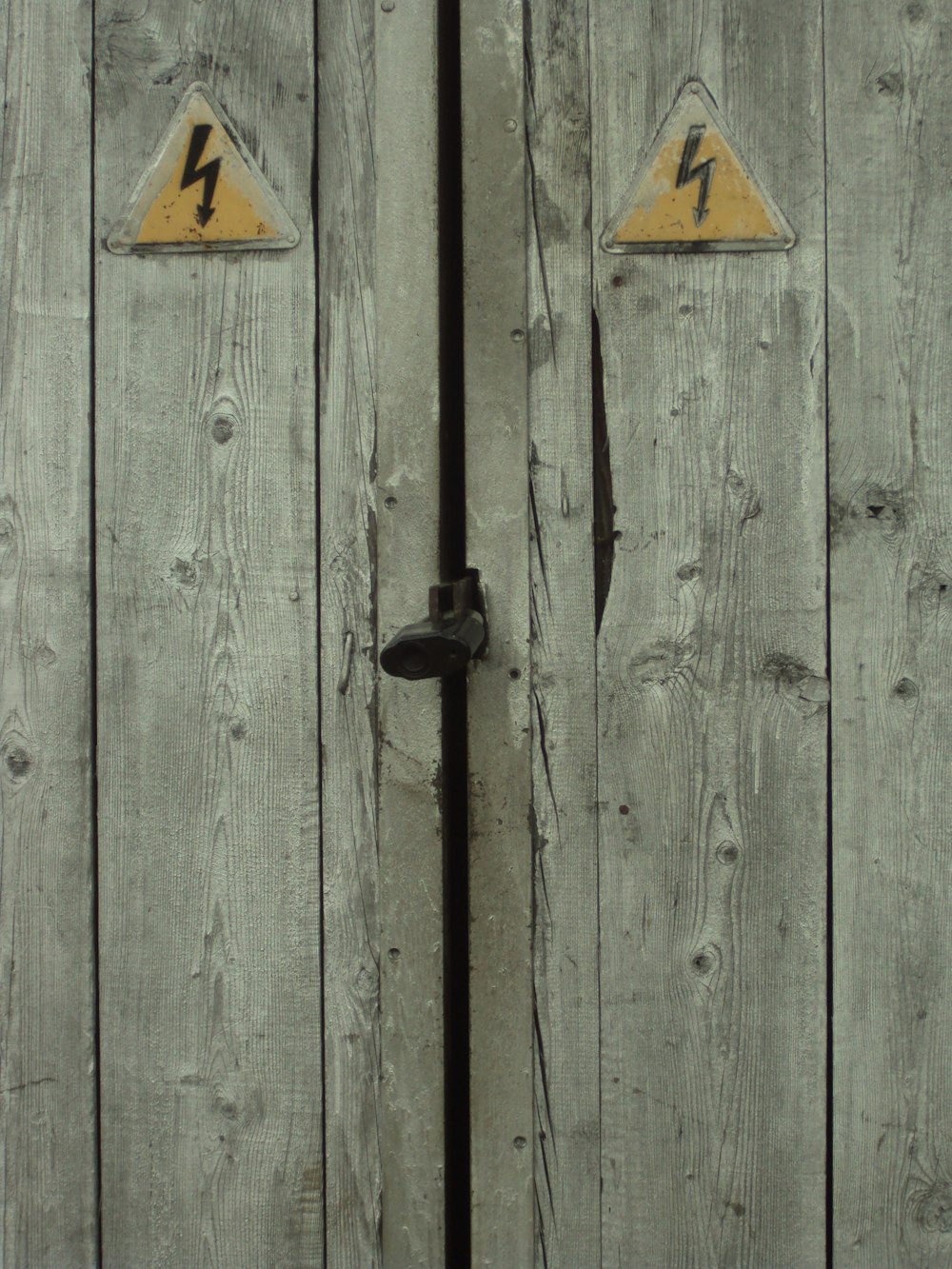 a close up of a wooden door with two signs on it