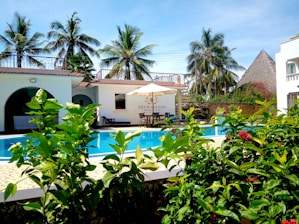a hotel with a swimming pool surrounded by greenery