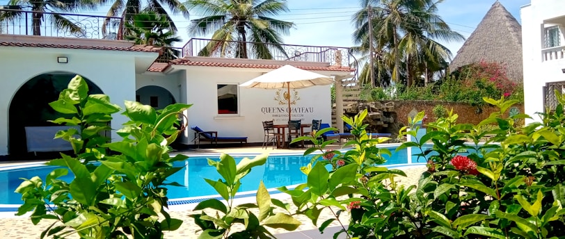 a hotel with a swimming pool surrounded by greenery