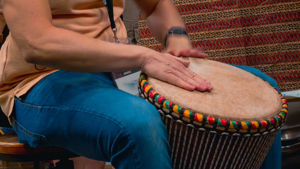 a person sitting on a chair with a drum