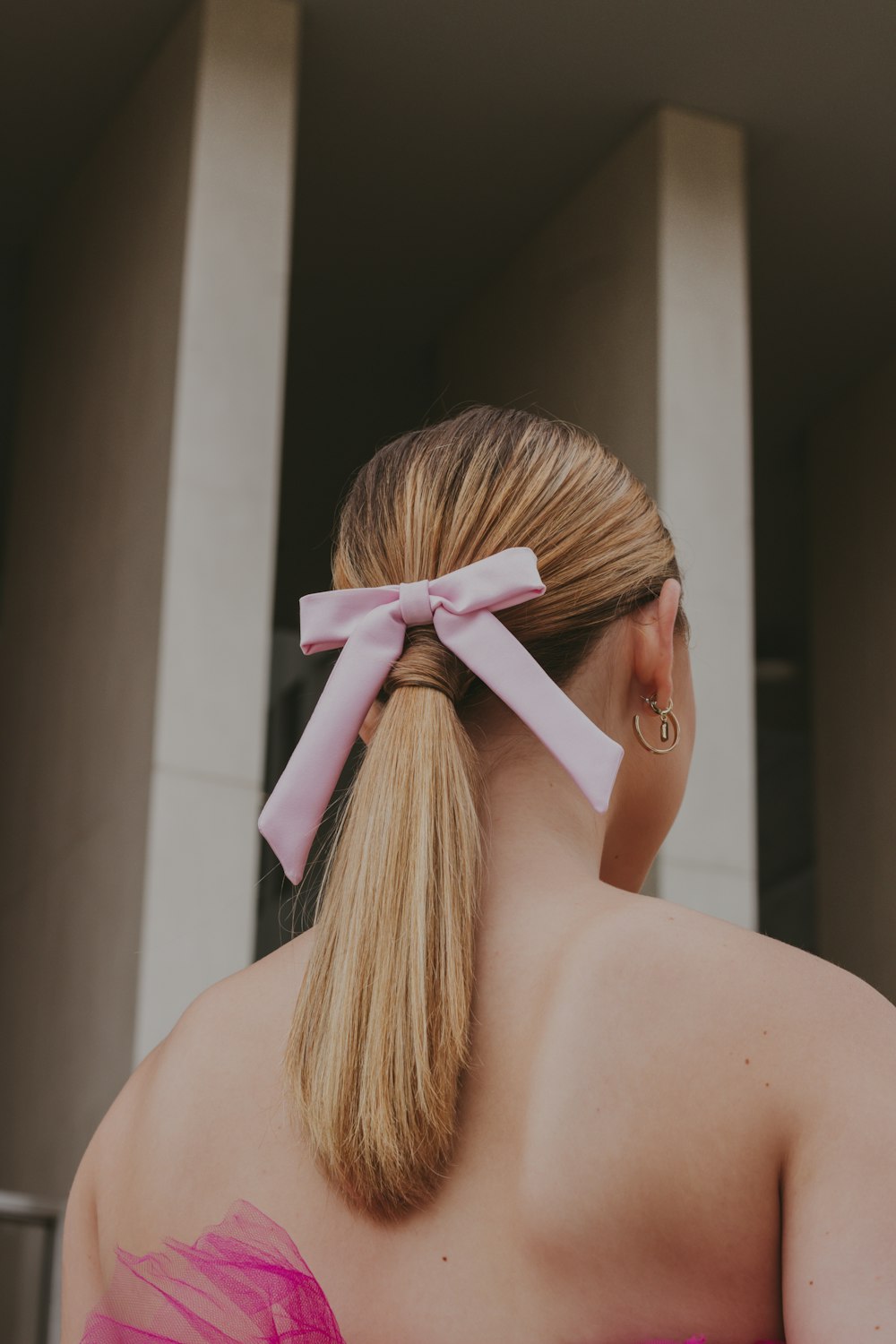 a woman in a pink dress with a pink bow in her hair