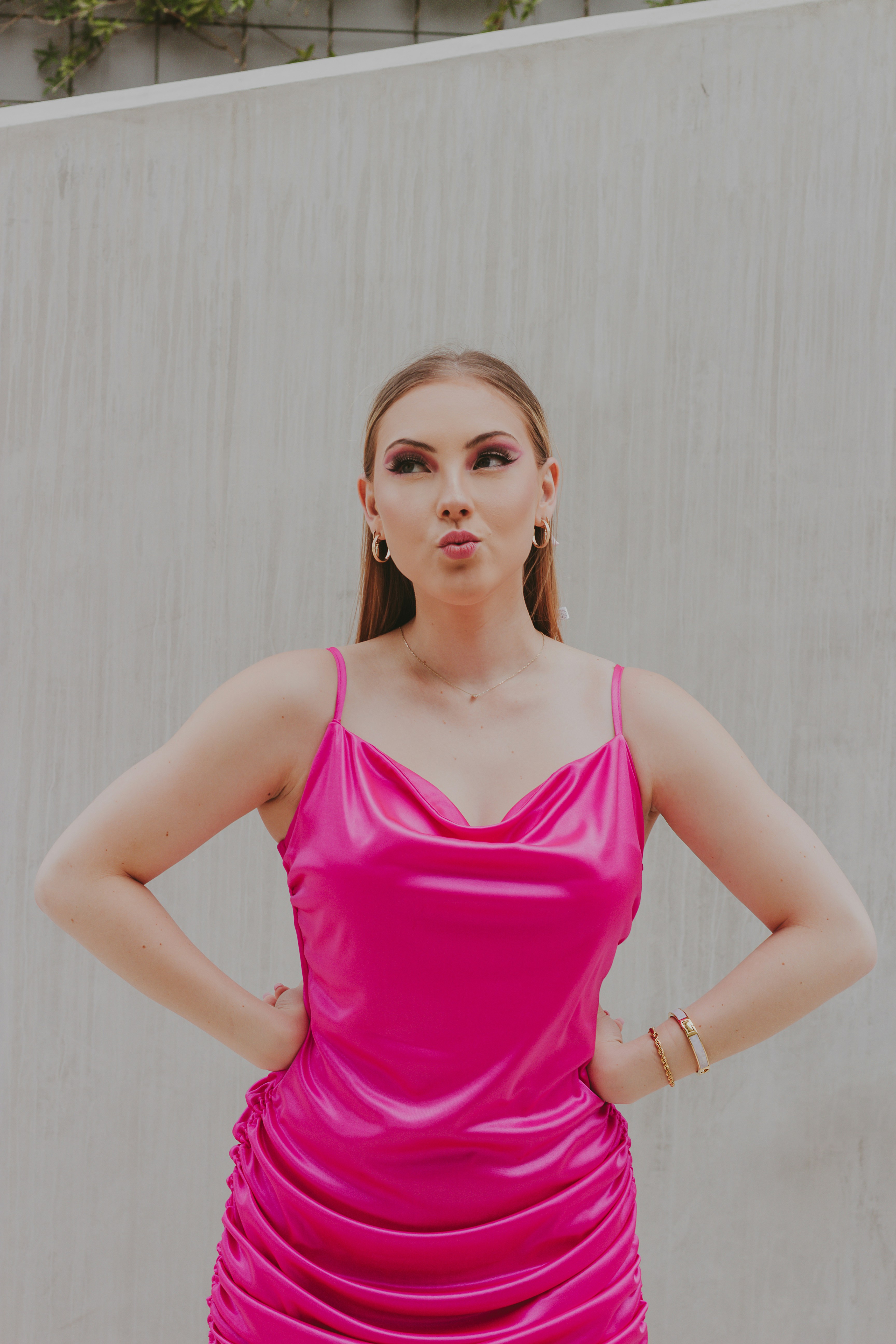 A woman in a pink dress standing with her hands on her hips photo ...