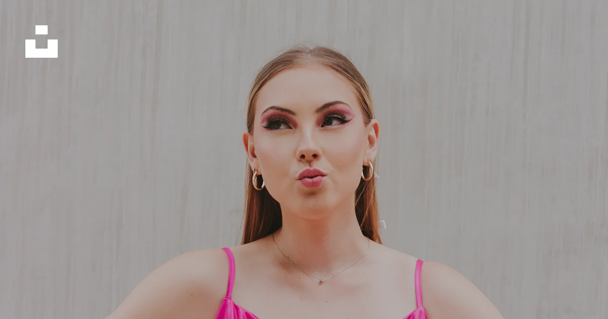 A woman in a pink dress standing with her hands on her hips photo ...
