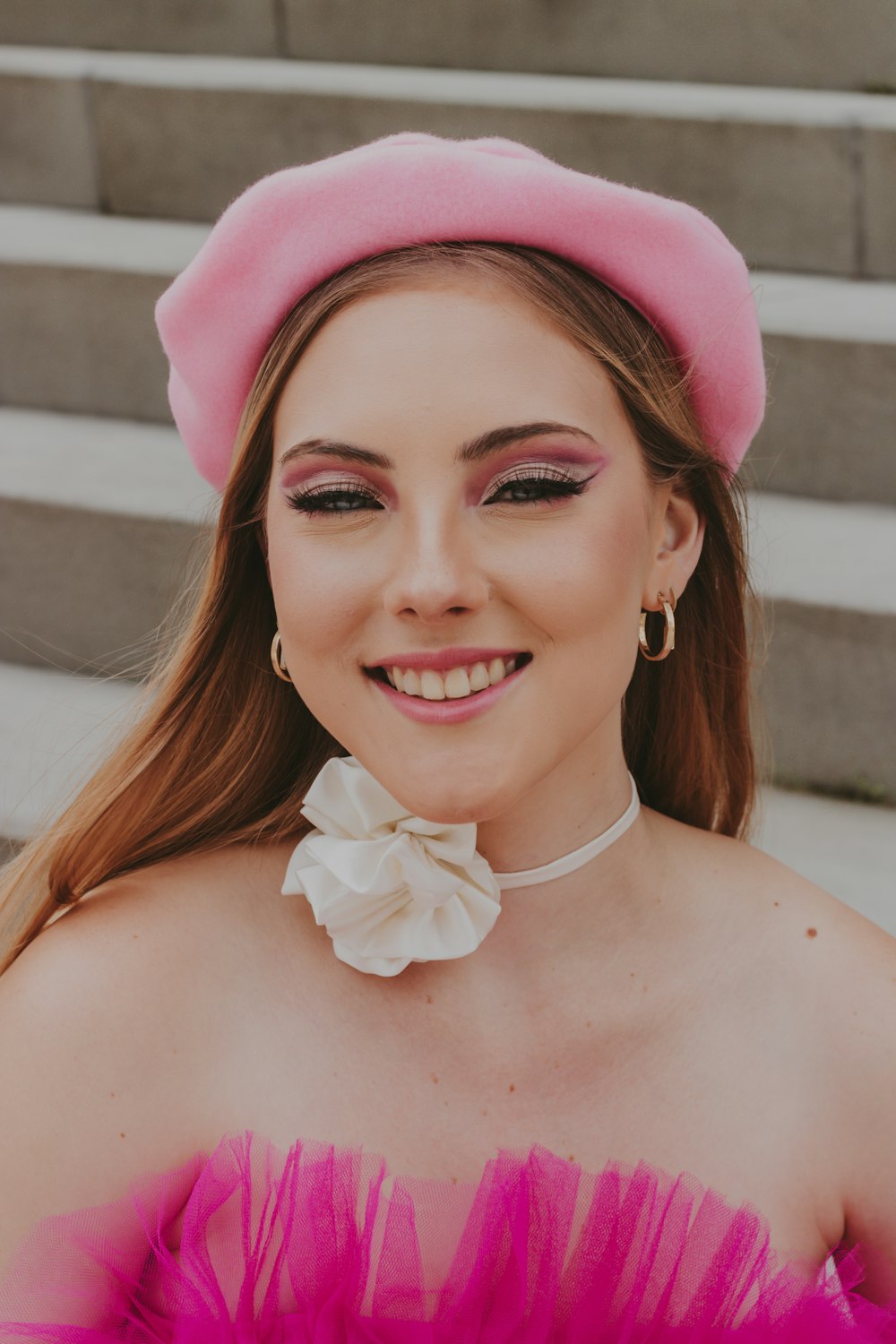 a woman wearing a pink hat and a pink dress