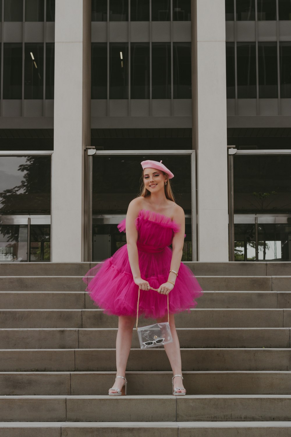 a woman in a pink dress standing on steps