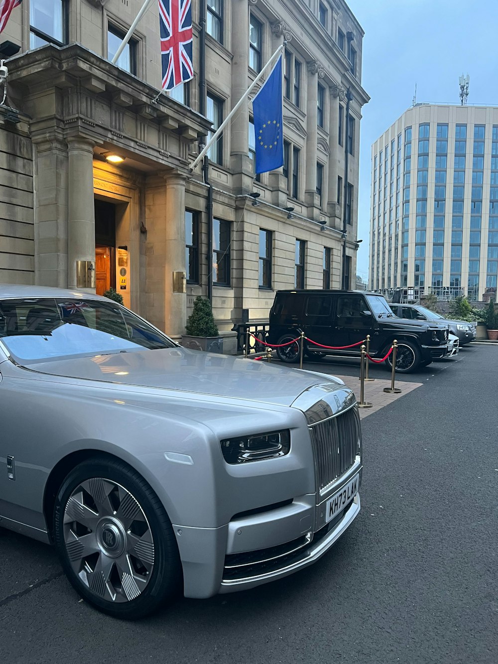 Um Rolls Royce prateado estacionado em frente a um prédio