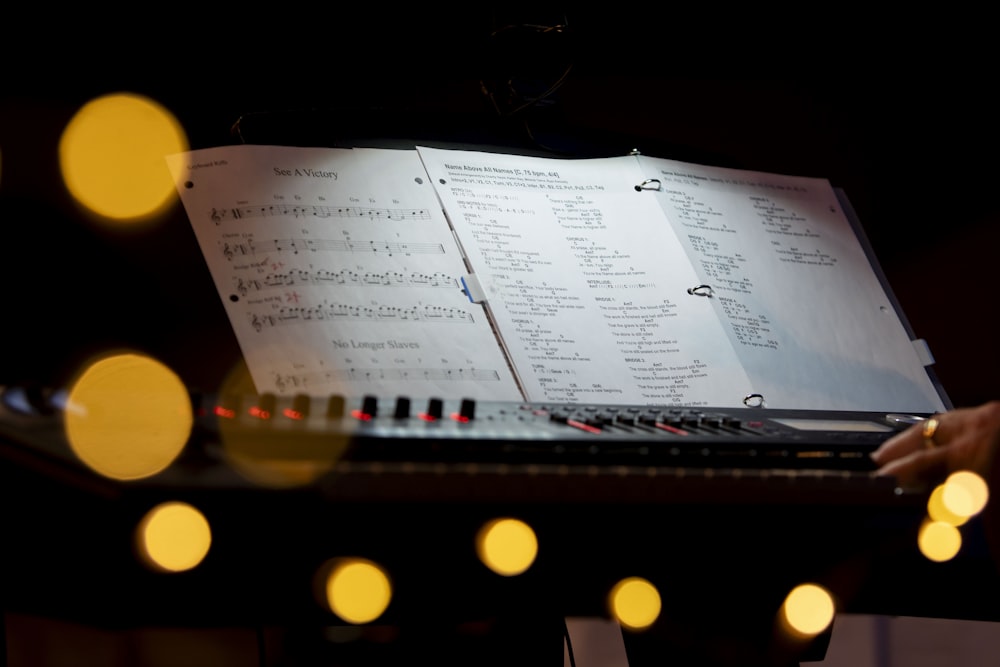 a keyboard with sheet music on it in a dark room